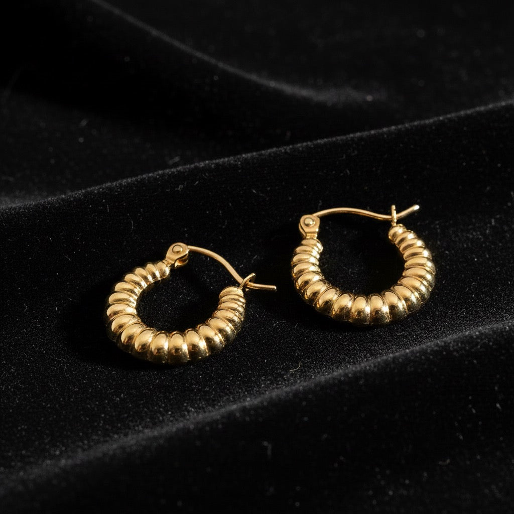 14K Yellow Gold Fancy Hollow Hoop Earrings laid on black velvet, showing polished hollow design and elegant shine.