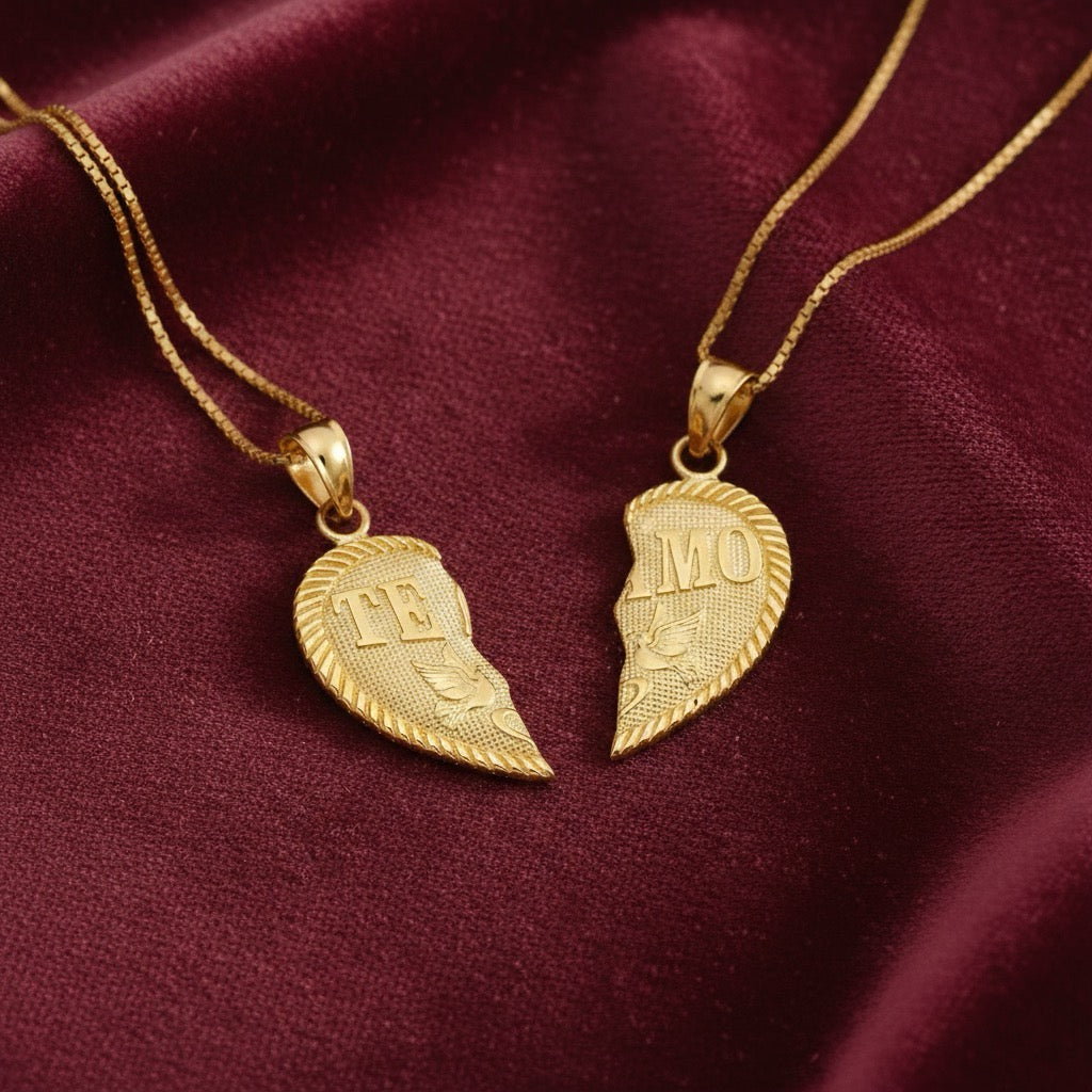 Close-up of 14K gold “Te Amo” heart pendant resting on a dark red fabric, designed to split in two for sharing between loved ones.