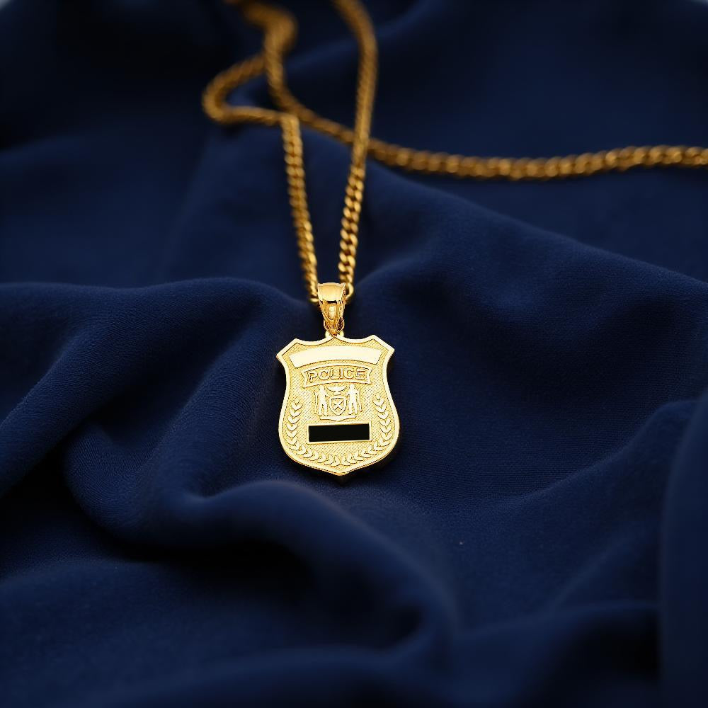 Close-up of a 14K Yellow Gold Police Badge Pendant displayed on a dark blue cloth, highlighting its clean detailing and elegant shine.