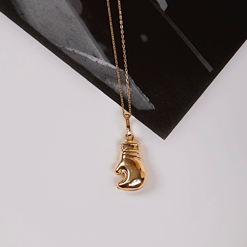 14K Gold Boxing Glove Pendant displayed on a plain background, highlighting its polished finish and intricate detailing.