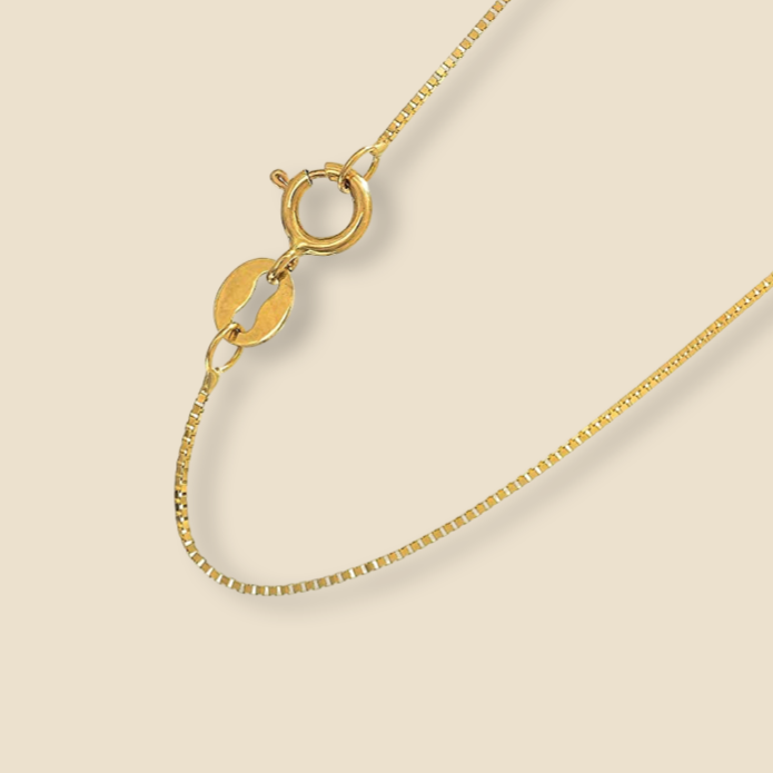 14K yellow gold 0.5mm box chain necklace displayed on a plain background, highlighting its sleek, polished finish and fine craftsmanship.