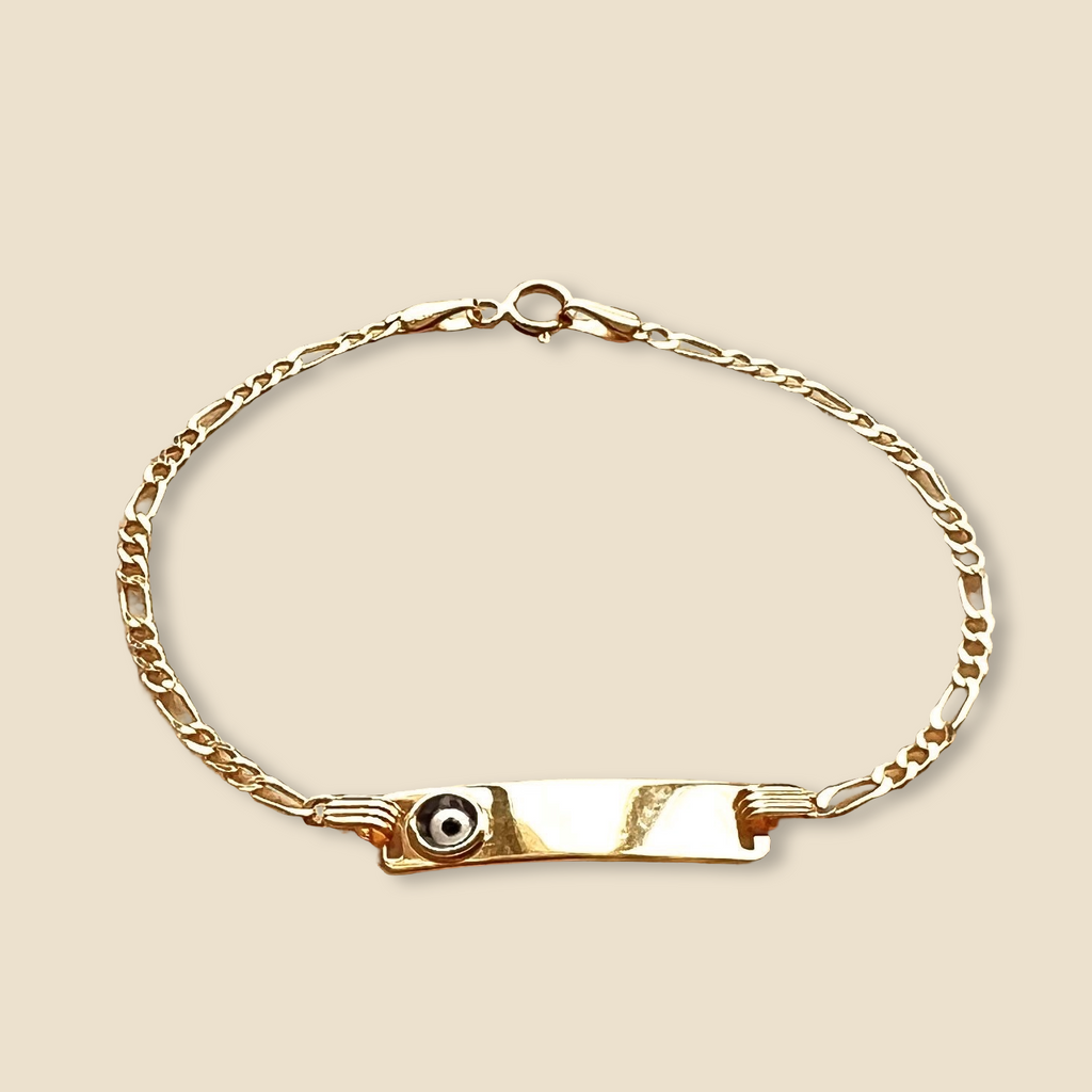 Tiny 14K gold baby bracelet with protective Evil Eye charm placed on a plain background, capturing the bracelet’s petite elegance, sentimental design, and gentle curves.