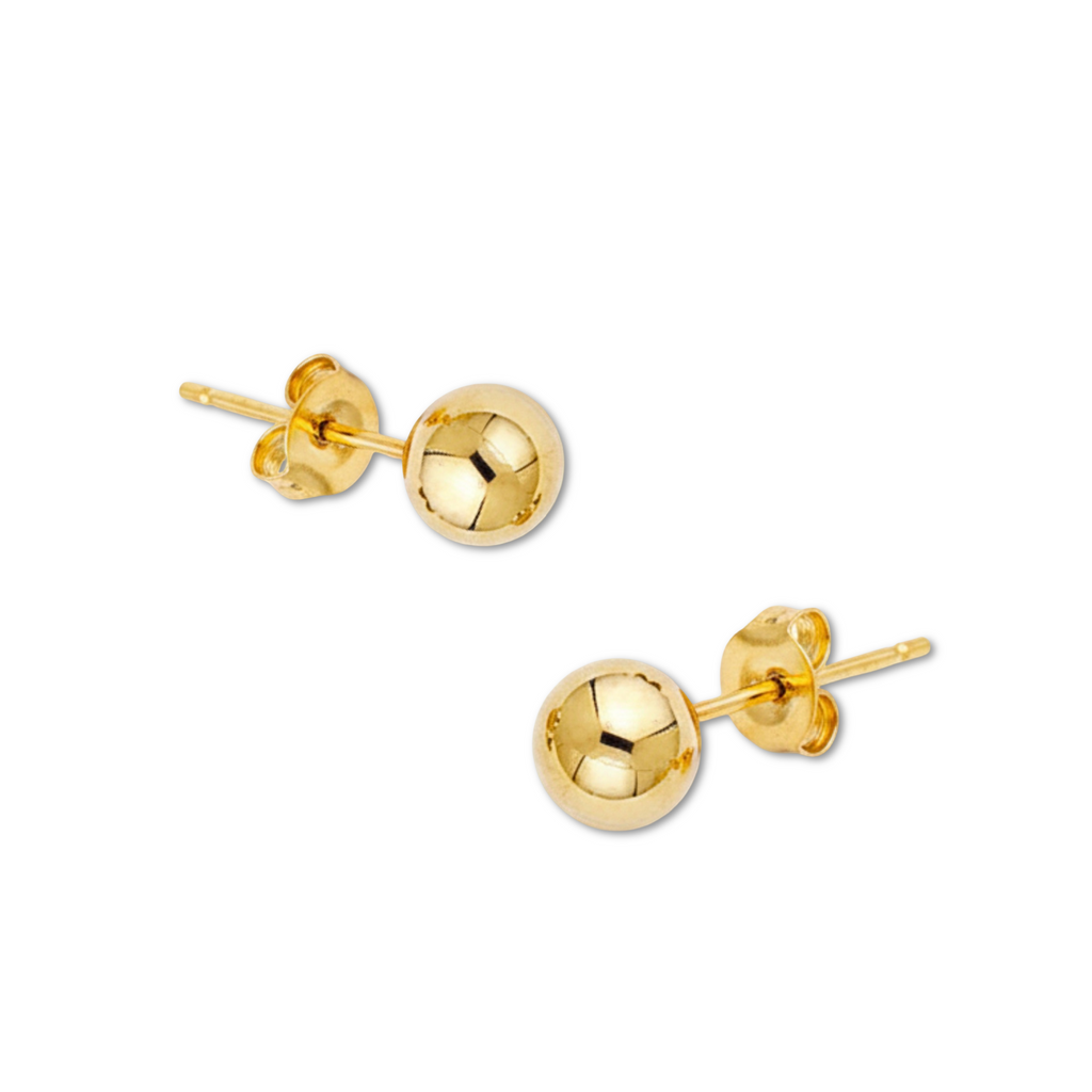 Studio image of polished 14K yellow gold ball earrings laid on a white plain background, revealing size and brilliance.