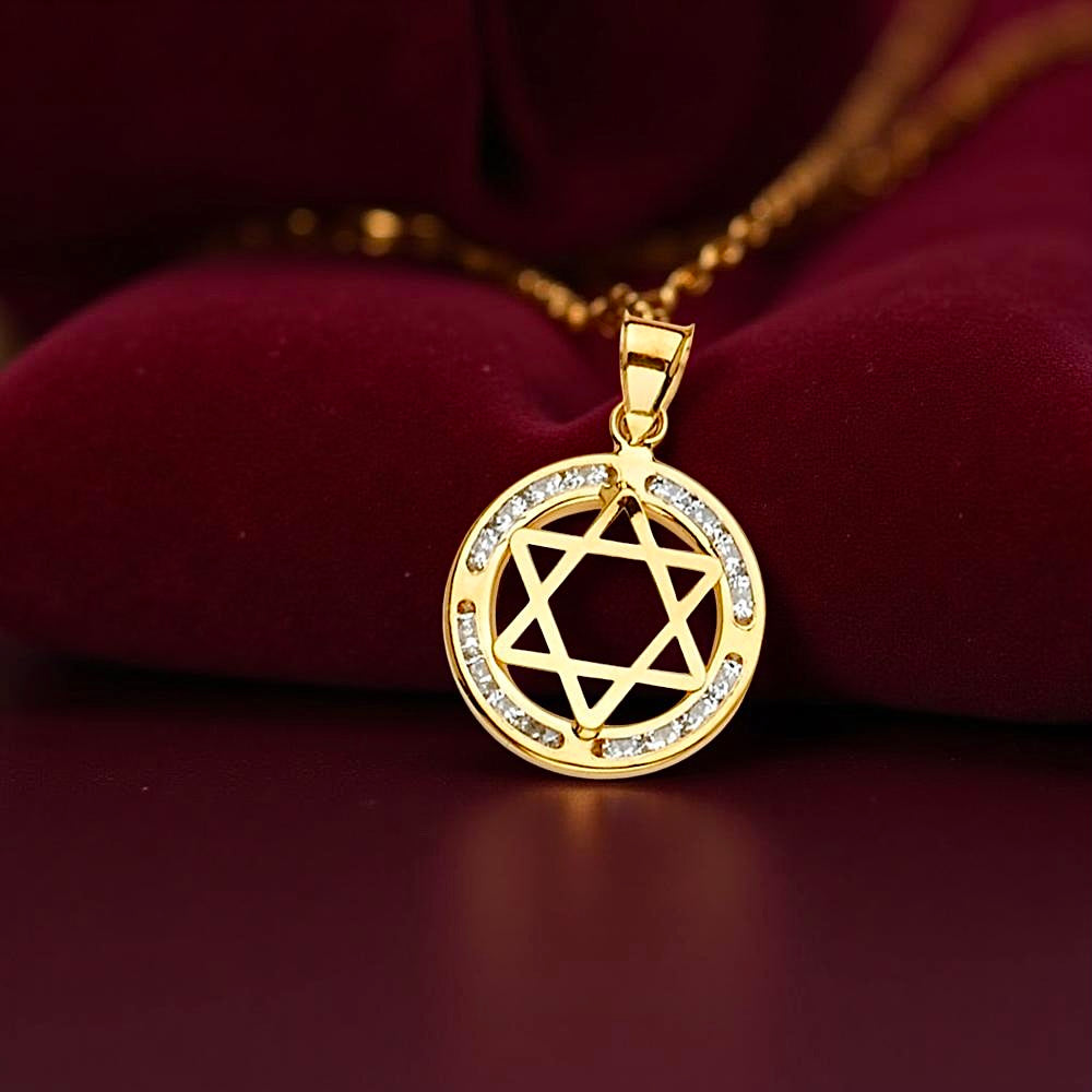 Elegant Star of David pendant with cubic zirconia set in 14K yellow gold, resting on a dark red velvet fabric for a warm and classic presentation.