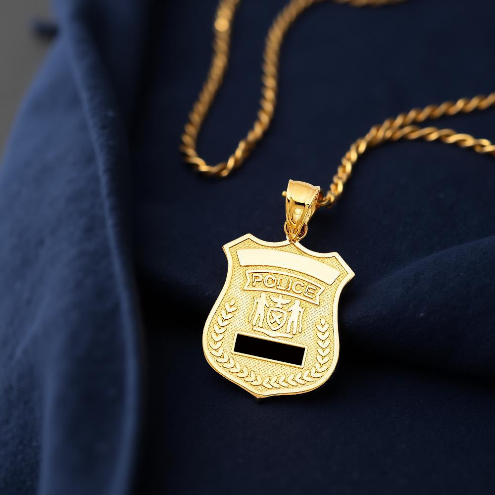 Close-up of a 14K Yellow Gold Police Badge Pendant displayed on a dark blue cloth, highlighting its clean detailing and elegant shine.
