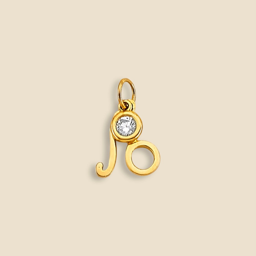 4K yellow gold Leo zodiac pendant with a sparkling cubic zirconia accent, displayed on a plain background to highlight its polished shine and intricate design.