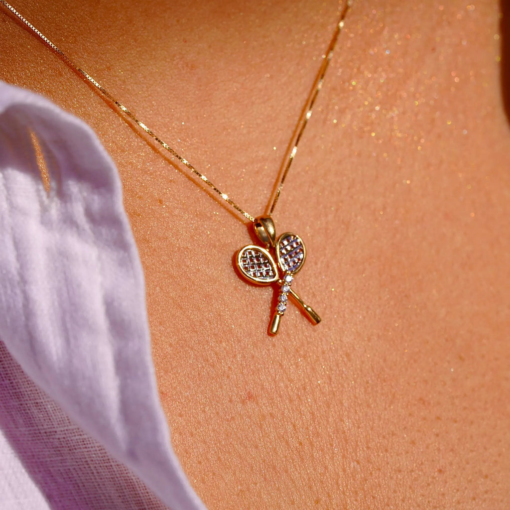 Close-up of a model wearing the 14K Gold Tennis Racquet Pendant, showcasing its elegant design and sparkling cubic zirconia stones.