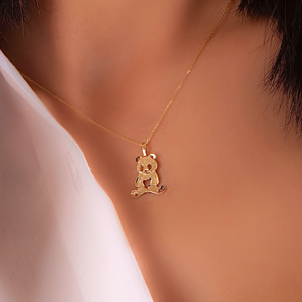 Model wearing a delicate 14K gold panda charm pendant on a chain, highlighting how the dainty design sits elegantly on the neckline, perfect for everyday wear or as a thoughtful gift.