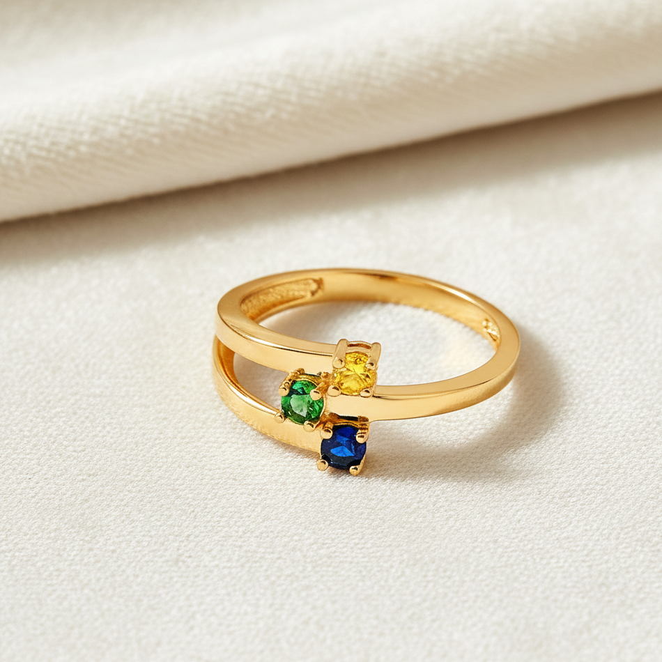 14K yellow gold 3-stone CZ month ring resting on cream velvet, highlighting sparkle and polished finish.