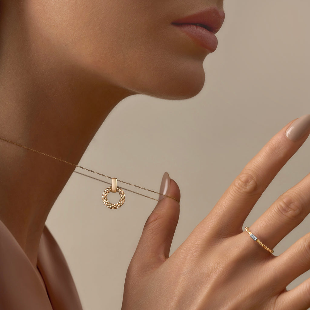 A model wears the 14K gold mesh pendant on a dainty gold chain, the intricate filigree design resting gracefully against her collarbone. The lightweight and elegant pendant adds a timeless touch to her outfit.