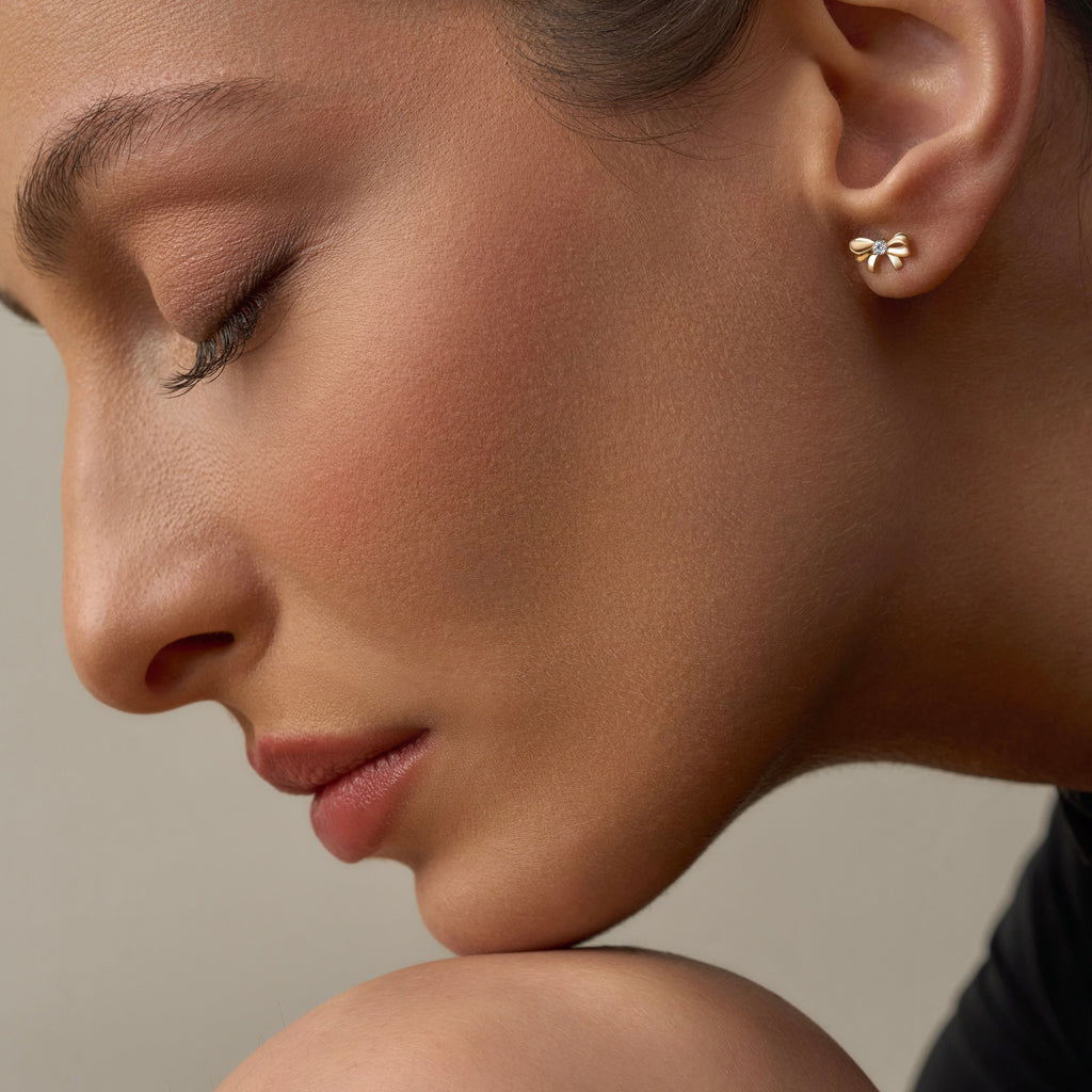 Model wearing 14K gold bowtie stud earrings, showing how the dainty bow design adds a touch of charm and timeless elegance to her everyday look.