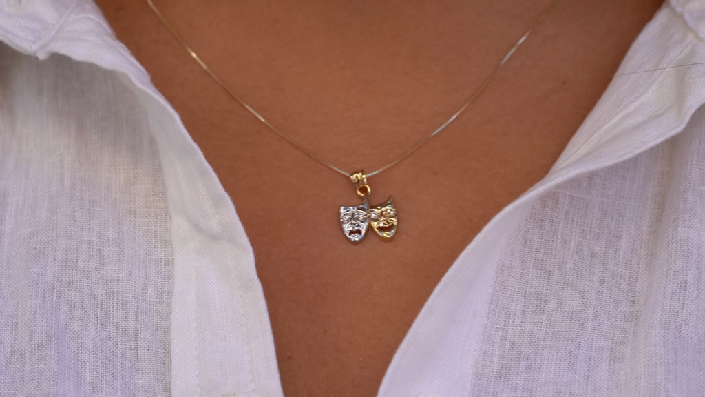 14K Two-Tone Solid Gold Comedy & Tragedy Charm worn by a model, showing close-up details of the theater mask design with cubic zirconia in white and yellow gold.
