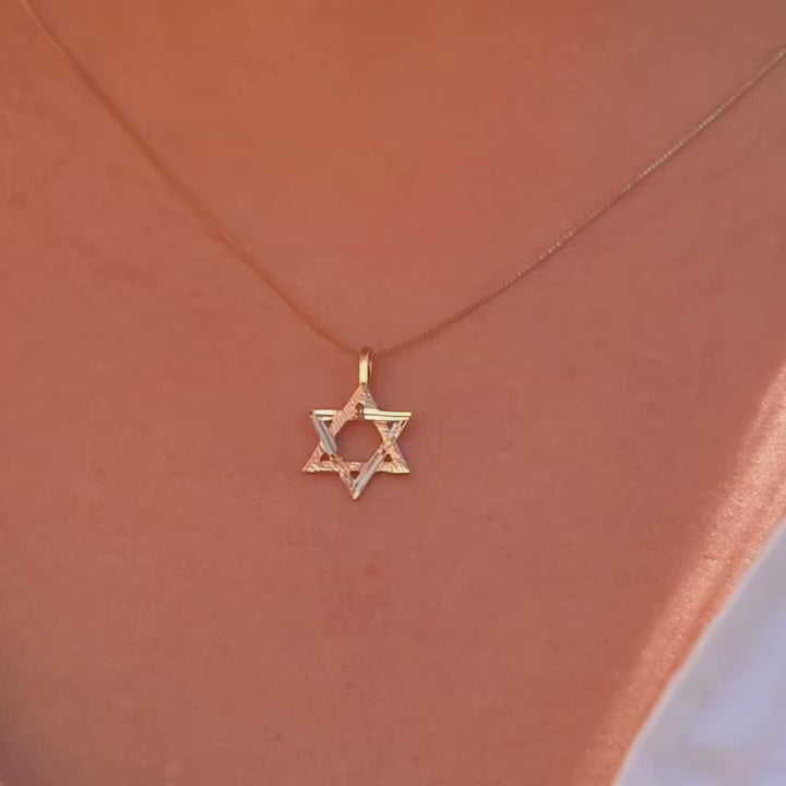A model wearing the 14K Gold Star of David Pendant on a delicate gold chain, with the pendant resting near their collarbone, adding a subtle touch of faith and elegance to their look.