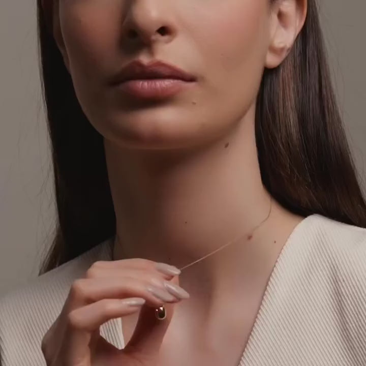 Model wearing a delicate 14K yellow gold cat pendant on a fine gold chain, showcasing its subtle shine and whimsical charm resting gracefully at the collarbone.