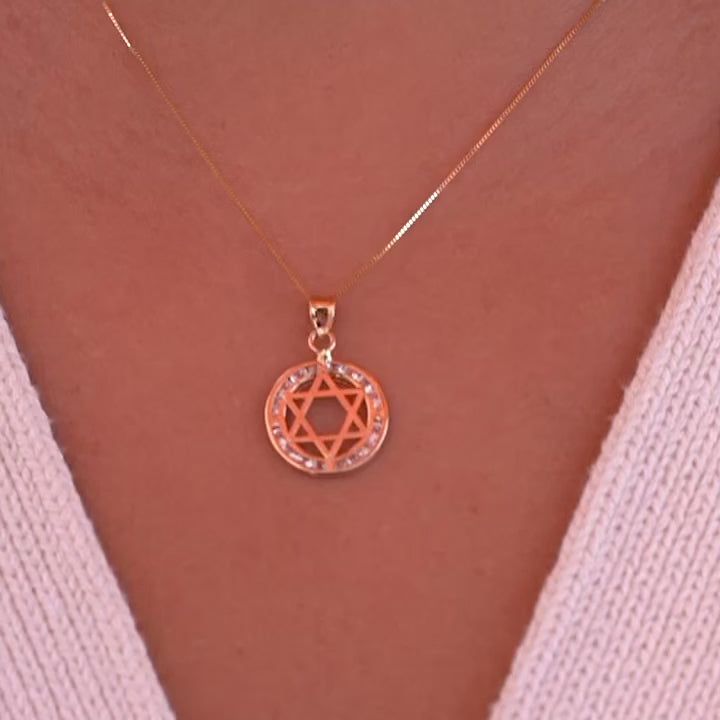 A model wearing the 14K gold Star of David pendant on a delicate gold chain, showcasing how the spiritual charm rests beautifully against the skin, with the CZ stones adding subtle sparkle.