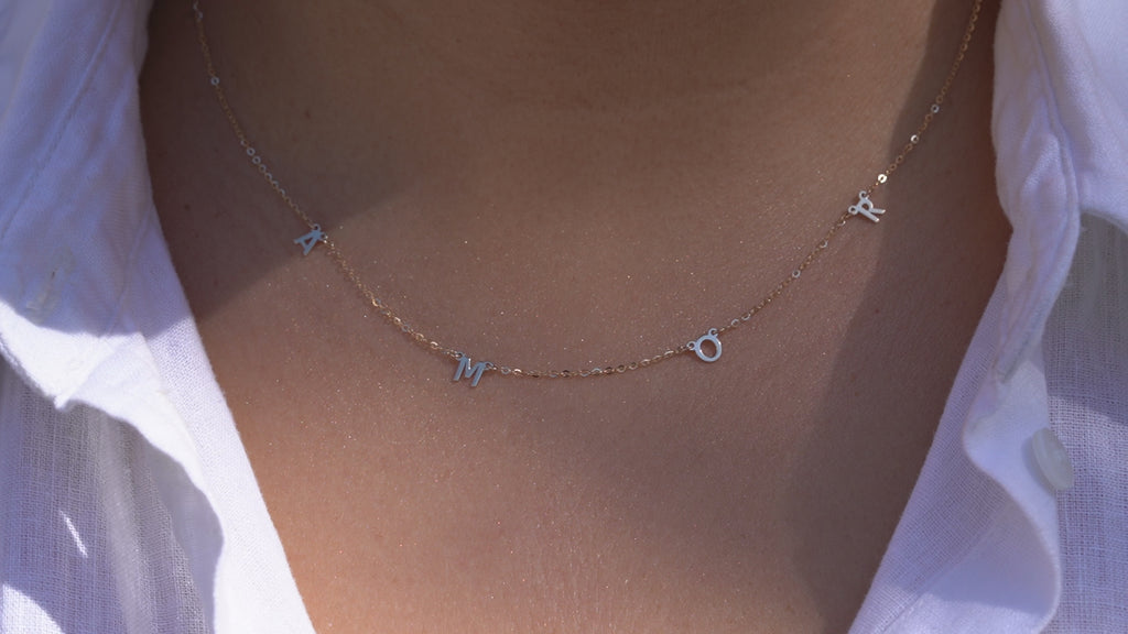 Video of Model wearing the 14K Gold AMOR Necklace, highlighting its elegant scripted 'AMOR' design, dainty gold chain, and adjustable fit for versatile styling.