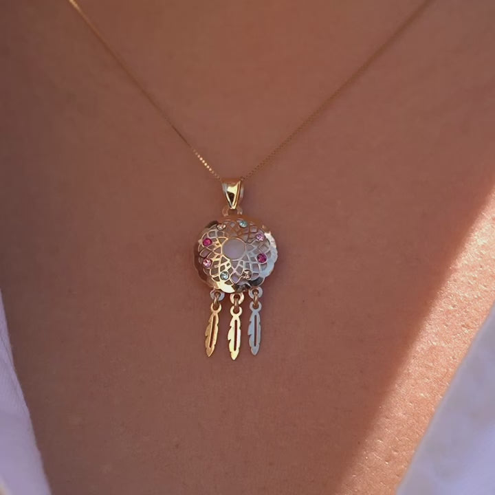 Model wearing a 14K yellow gold dreamcatcher pendant on a fine chain, the charm resting near the neckline, adding a touch of meaningful elegance and boho-inspired style.