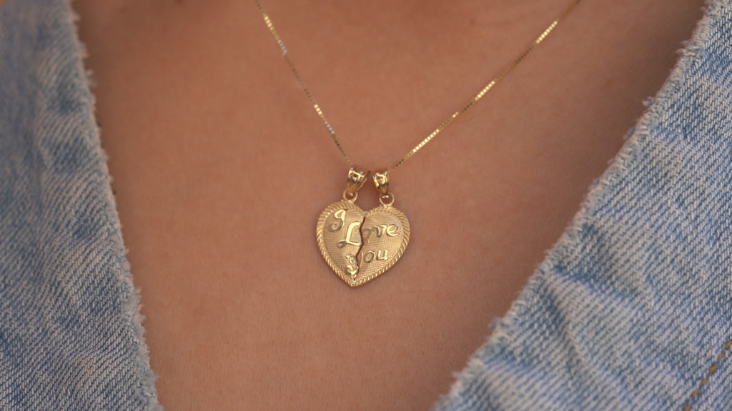 Video of a model wearing the 14K Gold 'I Love You' Breakable Heart Couple Charm on a chain, showcasing its elegant design, polished finish, and unique breakable feature from various angles.