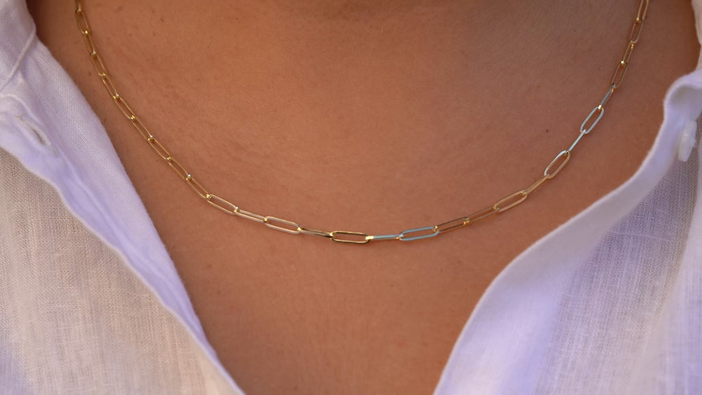 Video of a model wearing the 14K Solid Gold 3.0mm Solid Square Paperclip Chain Necklace, showcasing its polished square link design, radiant gold finish, and versatile length options in motion.