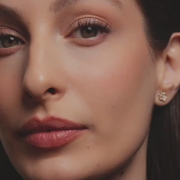 Model wearing 14K yellow gold wing stud earrings, showing how the delicate design adds a touch of elegance and symbolism to her look.