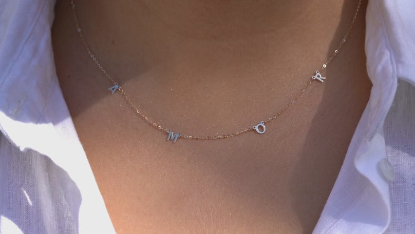 Video of Model wearing the 14K Gold AMOR Necklace, highlighting its elegant scripted 'AMOR' design, dainty gold chain, and adjustable fit for versatile styling.