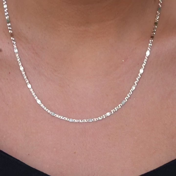 Model wearing the 14K tri-color 3mm Valentino Star Chain Necklace, showcasing its elegant shimmer and flat diamond-cut design against the skin.