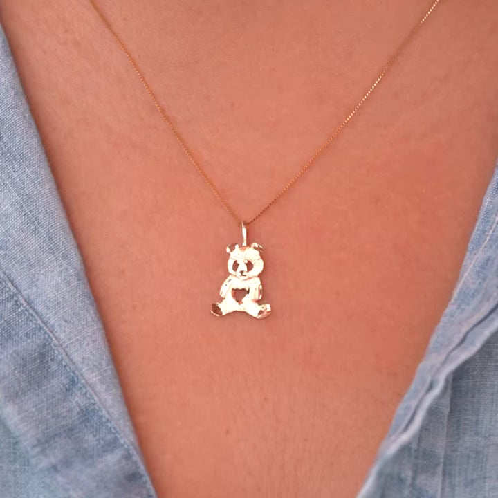 Model wearing a delicate 14K gold panda charm pendant on a chain, highlighting how the dainty design sits elegantly on the neckline, perfect for everyday wear or as a thoughtful gift.