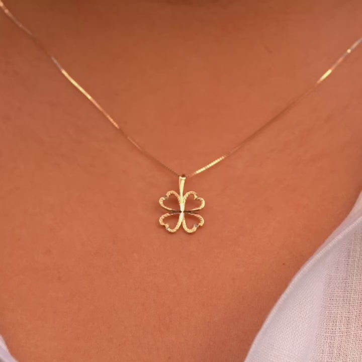 A model wearing the 14K Gold Heart Clover Pendant, showcasing its delicate heart-shaped clover design and radiant yellow gold finish.