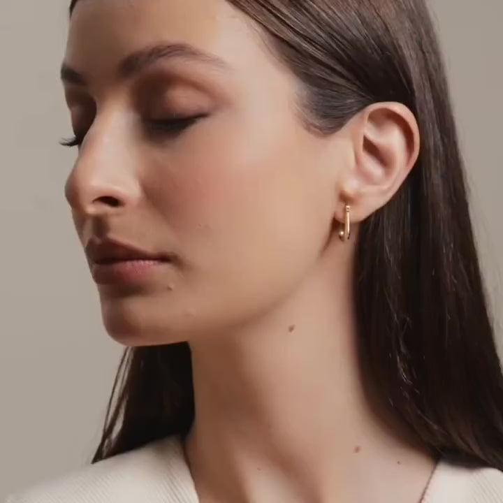 Model wearing 14K yellow gold CZ stud earrings, showcasing their delicate sparkle and timeless elegance for everyday wear.