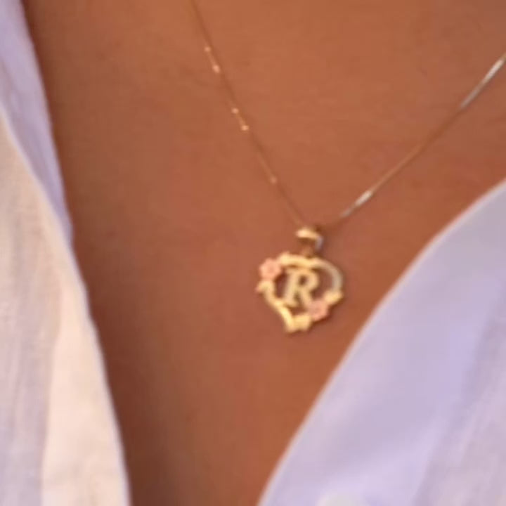 Model wearing the 14K Two-Tone Initial Heart Pendant with Letter R, highlighting the charm from the left side with elegant yellow and rose gold tones.