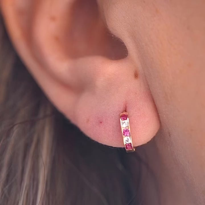 A stylish model wearing 14K Gold CZ Channel Set Hoop Huggies Earrings, showcasing their dainty size and elegant sparkle for everyday wear.