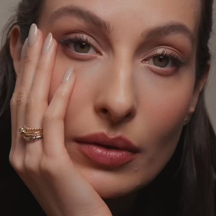 Close-up of a model’s hand wearing the 14K Two-Tone Fancy Ring stacked with other gold rings, showcasing a stylish layered jewelry look.