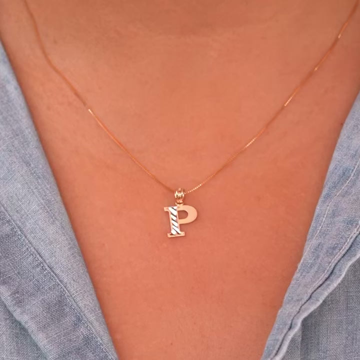 Model wearing a delicate 14K gold Initial P pendant necklace, layered with other fine chains for a personalized style statement.