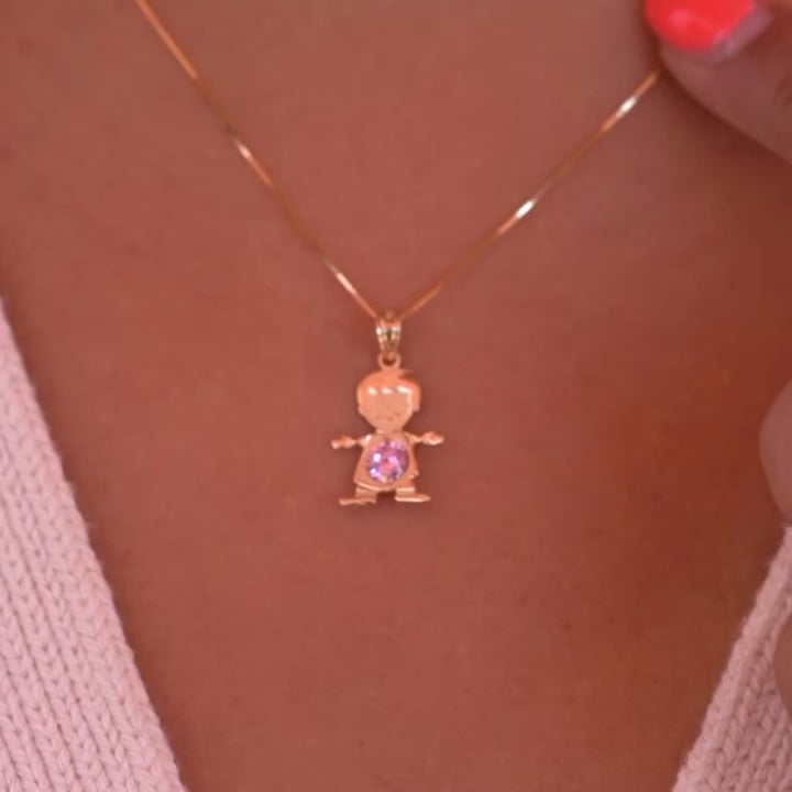 A model wearing the October birthstone boy charm on a delicate gold chain, showing how the 14K gold pendant sits lightly near the collarbone with the pink CZ sparkling subtly in the light.