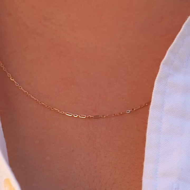 Model wearing a 14K gold 1.3mm chain, styled simply on the neck to show its everyday elegance and versatility.