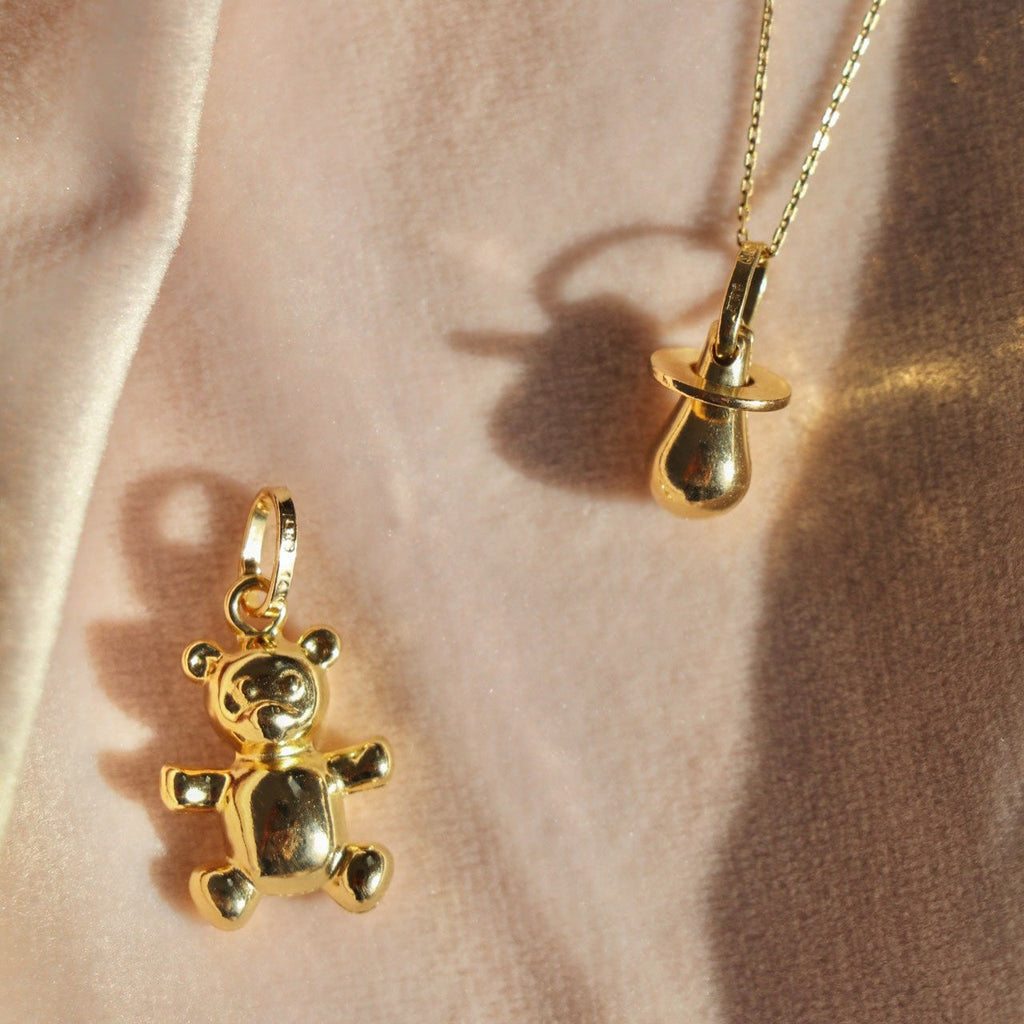 14K Real Gold Bear Pendant displayed alongside other gold charms on a flat surface, with a front-facing view highlighting its polished finish and intricate design.