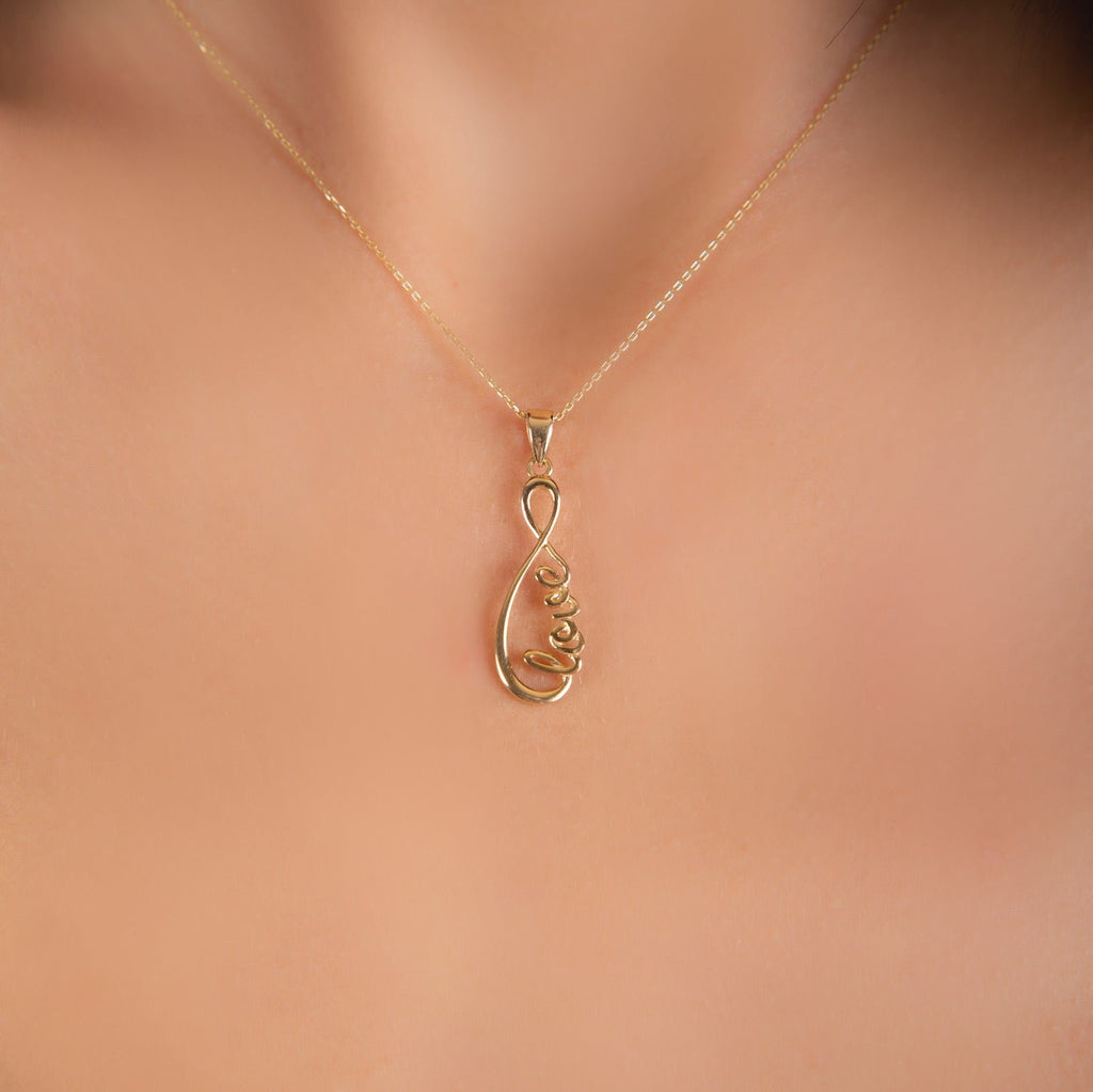 Model wearing 14K Solid Gold Love Infinity Pendant, front view showcasing the elegant infinity design with the word 'Love.