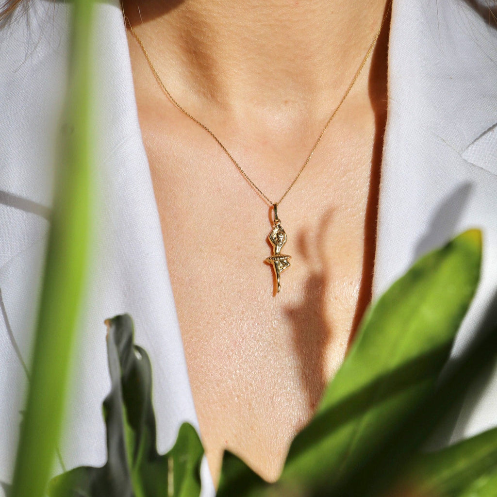 Model wearing the 14K Solid Gold Ballerina Charm on a necklace, captured from a slightly distant angle to showcase its graceful design and how it complements the overall look.