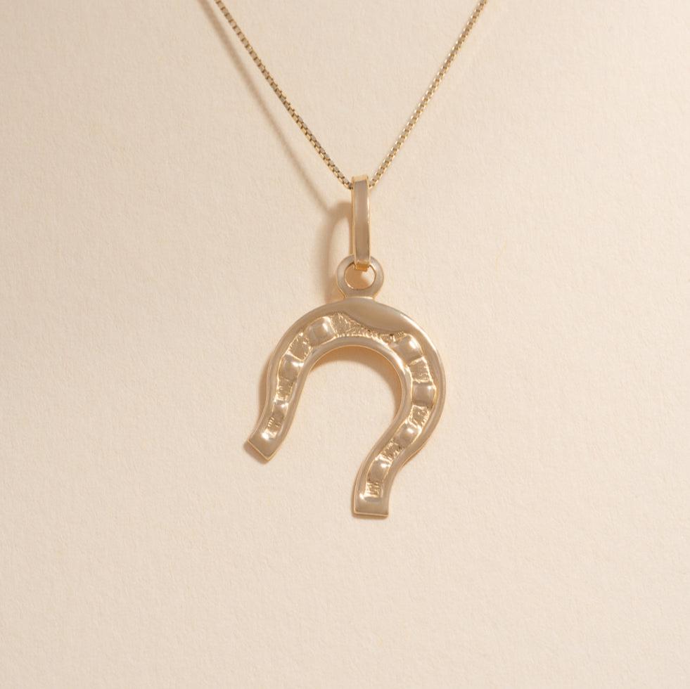 14K Solid Gold Horseshoe Charm hanging on a delicate gold chain, symbolizing good luck and protection with a polished and elegant design.