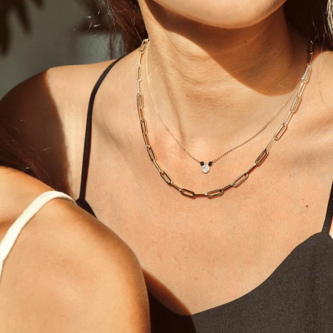 Model wearing the 14K Solid Gold Mouse Necklace layered with other necklaces, showcasing its dainty mouse pendant and how it complements a stylish layered jewelry look.